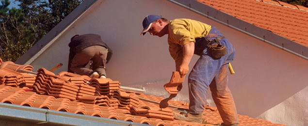 Hombres reparando el techo de una casa